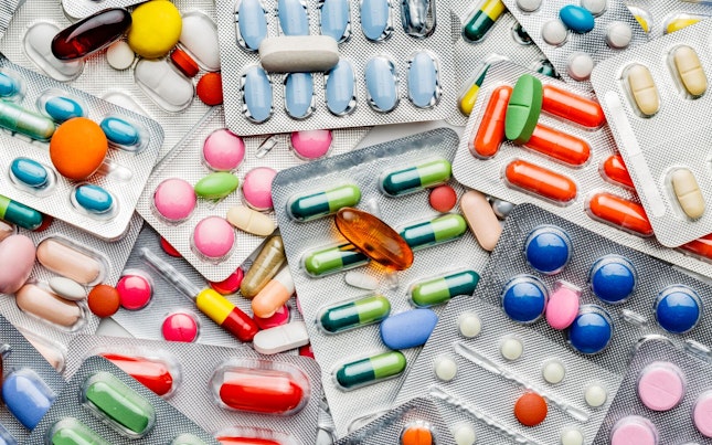 Health themes. Background of a large group of assorted capsules, pills and blisters. Drug abuse.
